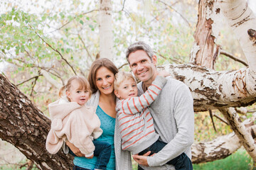 Fototapeta premium Portrait smiling family in front of tree