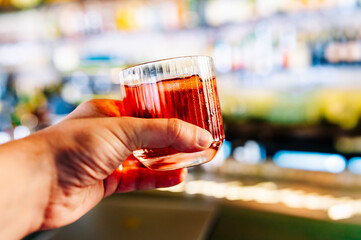 man hand hold glass coktail in bar