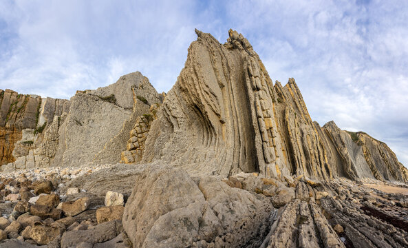 Colorful rock formations (Flysch) in a landscape of the Portio beach at sunset in Cantabria, north of Spain.