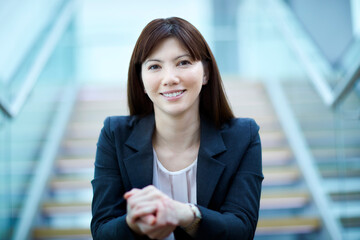 Portrait confident businesswoman sitting on stairs