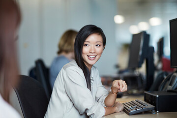 Smiling businesswoman talking to colleague in office