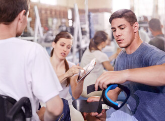 Obraz premium Physical therapists with digital tablet and equipment talking to man