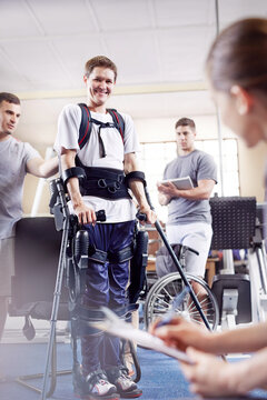 Smiling man with forearm crutches in physical therapy
