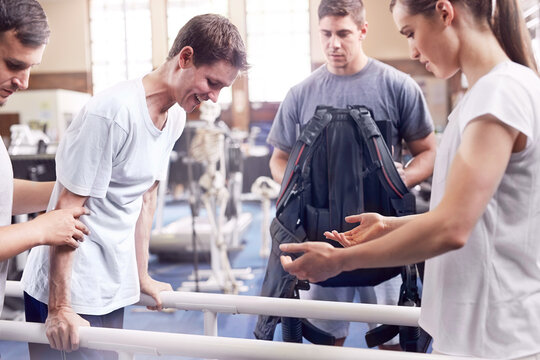 Physical therapists guiding man walking