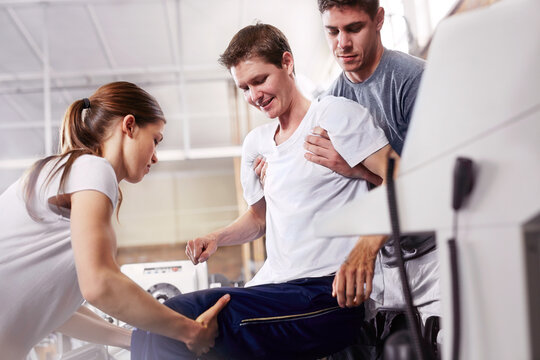 Physical therapists lifting man