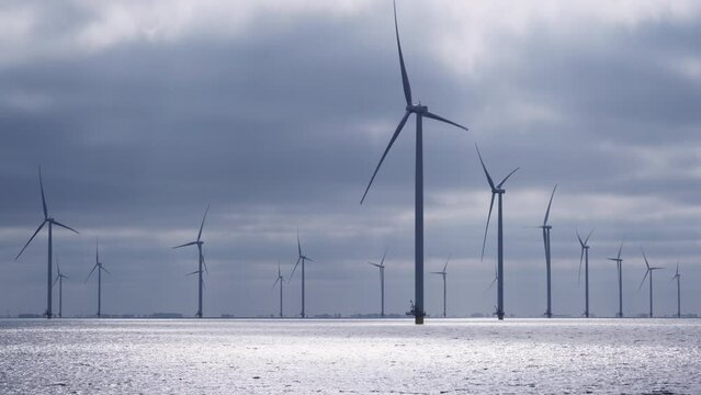 An offshore wind farm in the early morning light. Windpark Frysl&acirc;n was built in the IJsselmeer lake in the Netherlands and is the largest in the world in an inland water.
