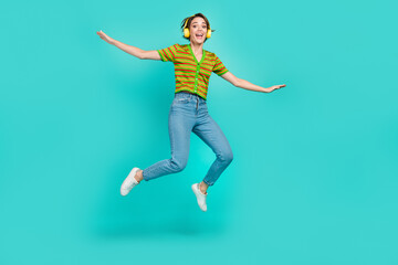 Fototapeta na wymiar Full length photo of overjoyed person jumping enjoy listen favorite song isolated on teal color background