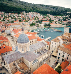 Obraz premium Beautiful view with picturesque red roofs of Dubrovnik old town and marina with boats, Croatia.