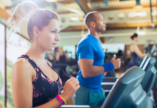 Focused woman running on treadmill at gym
