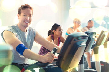 Portrait smiling man riding exercise bike at gym