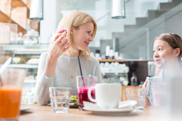 Mother and daughter eating at cafe table