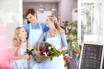 Florists smiling and hugging in flower shop