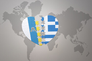 puzzle heart with the national flag of greece and canary islands on a world map background.Concept.