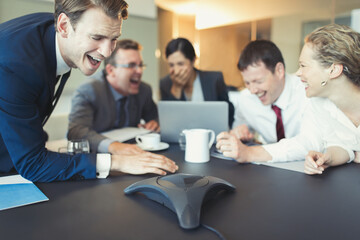 Laughing business people on conference call in conference room