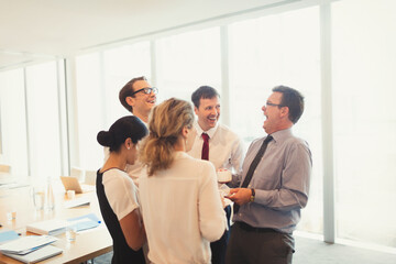 Laughing business people enjoying coffee break in conference room