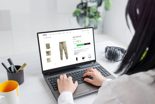 Woman browsing online for cargo pants, exploring stylish options and finding the perfect fit for her wardrobe. Modern ecommerce web site on laptop display
