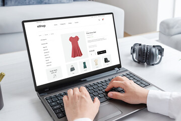 Woman purchasing a stunning red dress online with laptop computer. Modern ecommerce web page interface - obrazy, fototapety, plakaty