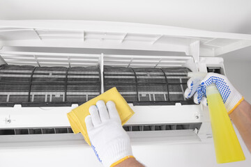 Service guy cleaning and maintaining air condition unit.