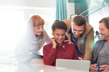 Fototapeta premium Creative business people sharing laptop in meeting