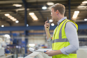 Supervisor using walkie-talkie in steel factory