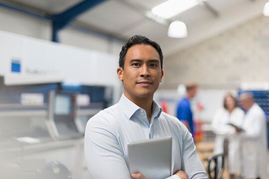 Portrait confident manager with digital tablet in steel factory