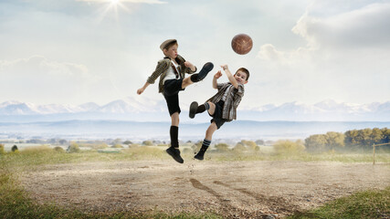 Happy, active, little boys, children in retro style clothes playing football outdoors on a daytime