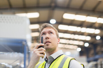 Supervisor using walkie-talkie in steel factory