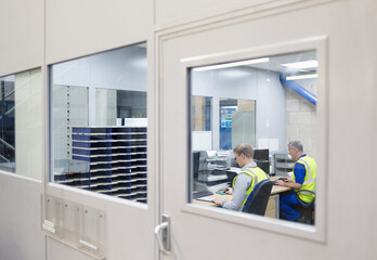 Workers working at computers in steel factory office