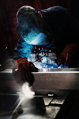 Welder using welding torch in steel factory - obrazy, fototapety, plakaty