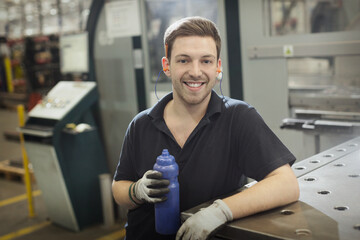 Portrait smiling worker with water bottle in steel factory