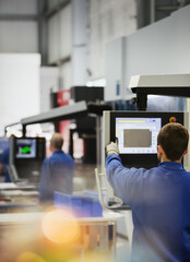 Worker at control panel in steel factory