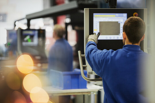 Worker at control panel in steel factory