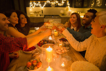Friends toasting champagne glasses at candlelight table