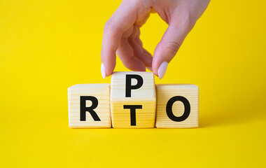 RPO vs RTO symbol. Businessman hand turns wooden cubes and changes the word RTO to RPO. Beautiful...
