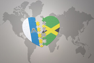 puzzle heart with the national flag of jamaica and canary islands on a world map background.Concept.