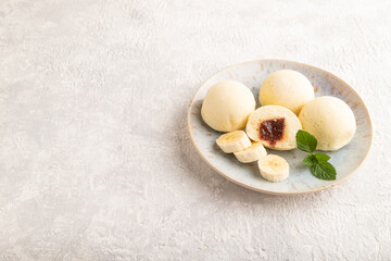 Japanese rice sweet buns mochi filled with jam on a gray concrete. side view, copy space.