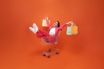 happy smiling Fashionable woman with trolley and shopping bags walking shopping promotion summer...