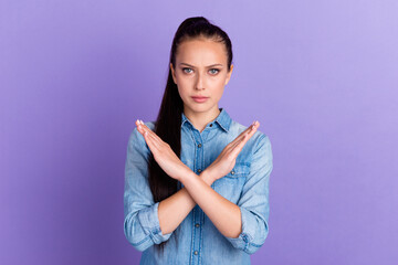 Lady making stop gesture with her palm isolated on purple color background