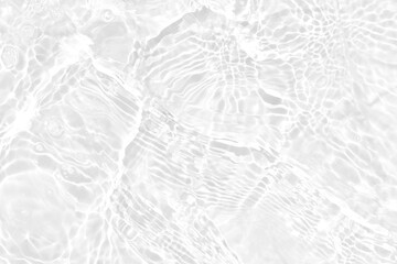 White water with ripples on the surface. Defocus blurred transparent white colored clear calm water surface texture with splashes and bubbles. Water waves with shining pattern texture background.