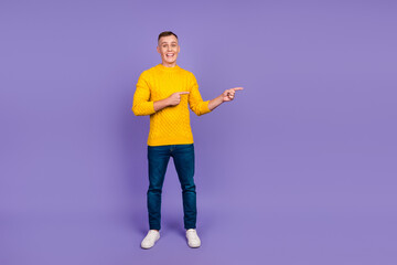Full size photo of handsome guy casual dressed indicating empty space promo isolated purple color background