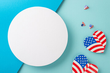 Labor Day USA festive well wishes. Overhead perspective of embellishments: hearts adorned with the American flag motif on bicolor blue backdrop with a blank circle for messages or promotions