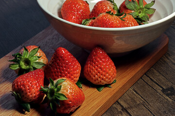 strawberries in a bowl on a wooden table
