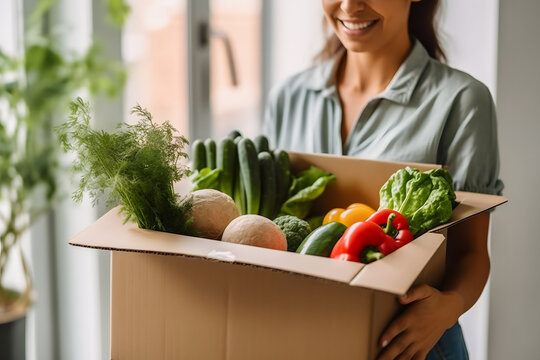 Woman Unboxing Fresh Groceries: Convenient Delivery of Vegetables