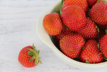 Strawberries in bow on white table top view. Beautiful red strawberry