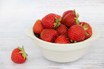 Strawberries in bow on white table top view. Beautiful red strawberry