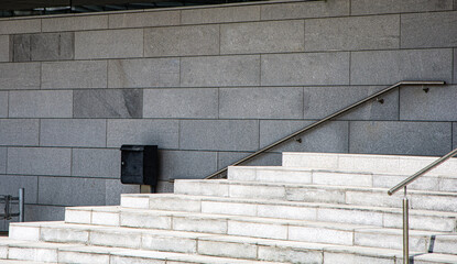 Gray marble staircase and gray concrete wall. Steps to the top.