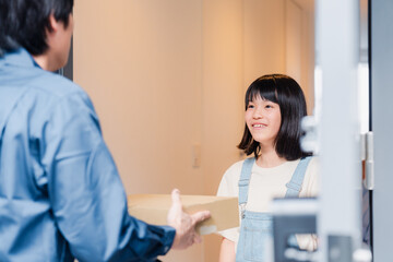 Fototapeta premium 家で宅配便を受け取る小学生の女の子
