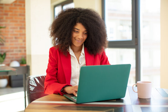 pretty afro black woman smiling and looking with a happy confident expression. businesswoman and laptop concept