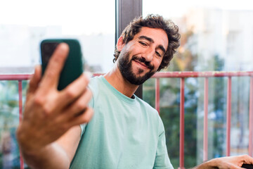 young adult crazy bearded man with a smartphone. interior  view