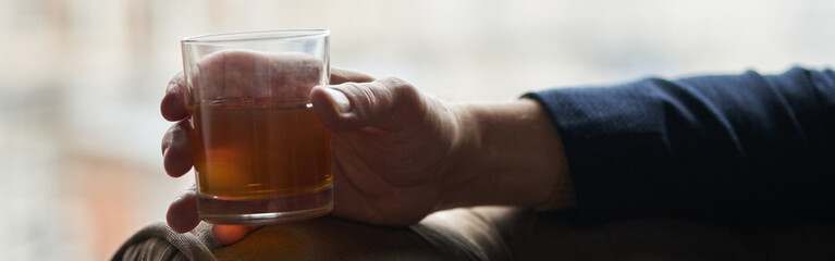 Close up shot of hand of successful business man holding glass o